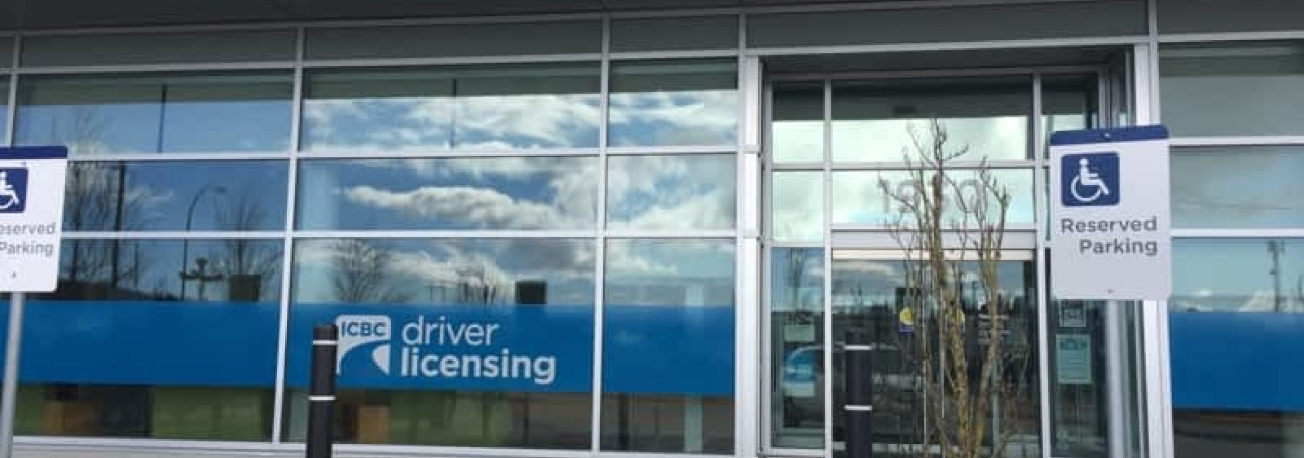 Exterior of an ICBC driver licensing office with accessible parking signs